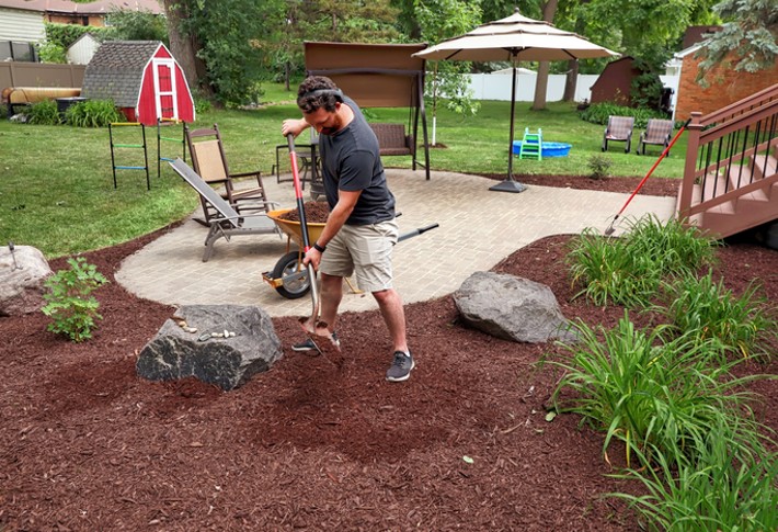 A man using mulch glue on his garden