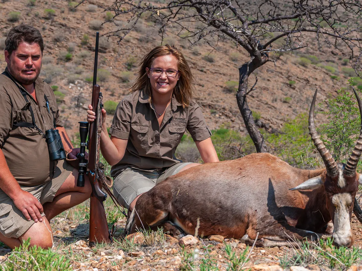 A women proudly showing off her hunted deer