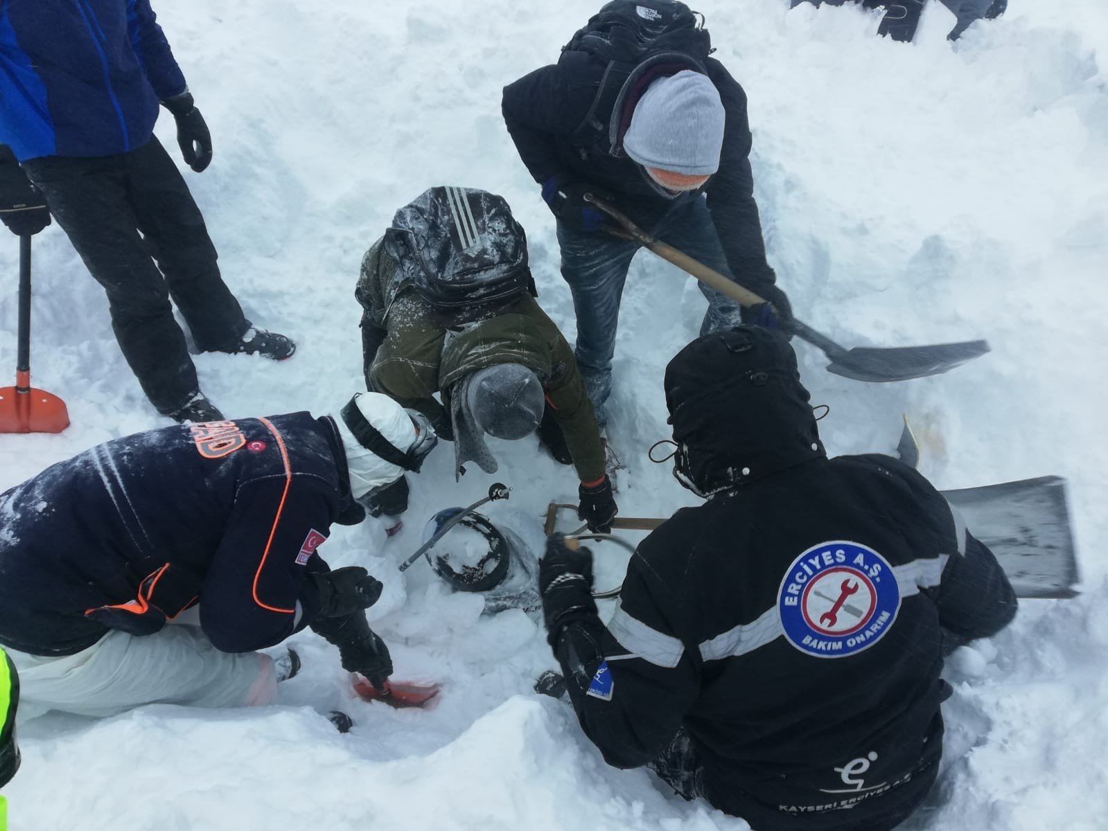 Rescuers saving a man buried in snow